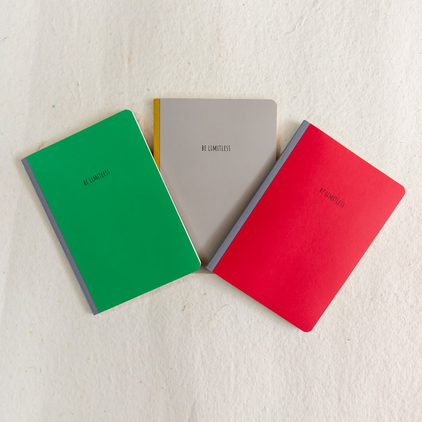 Be Limitless notebooks in green, grey and red