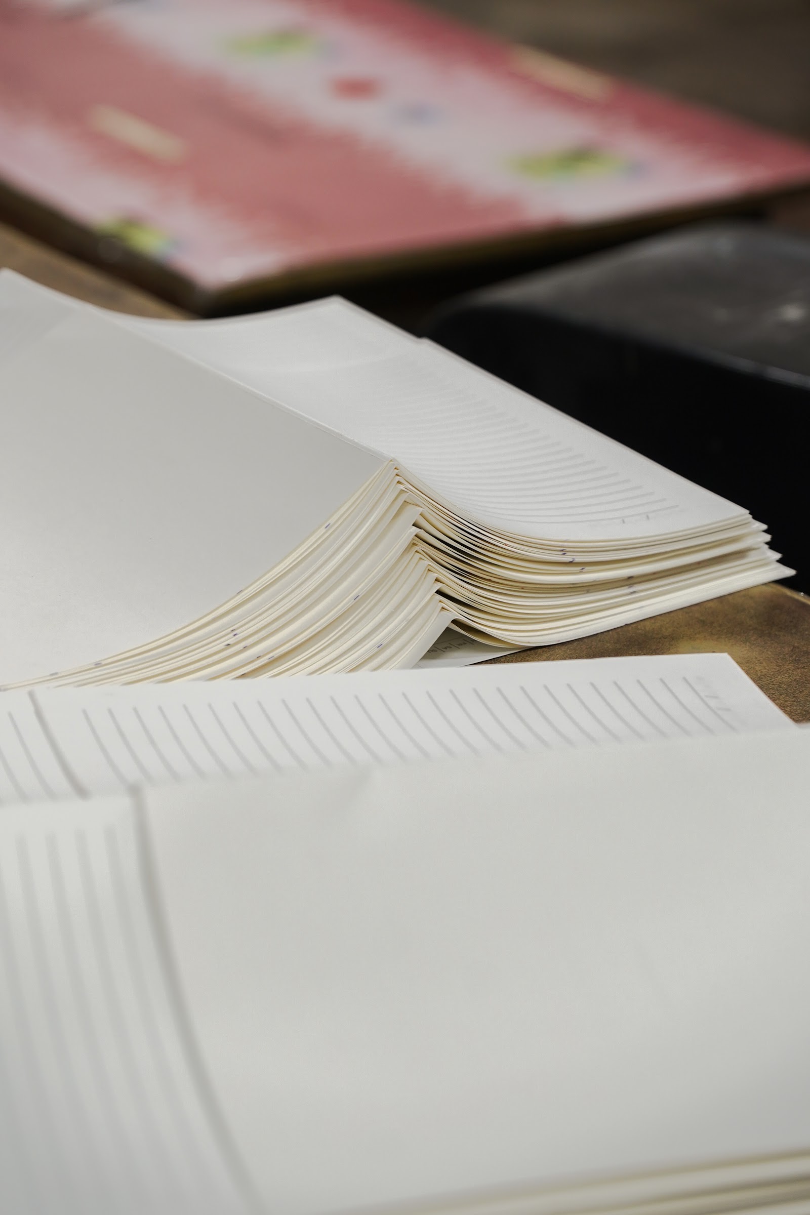 A cut stack of paper signatures on the workshop bench